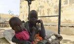 Des enfants soudanais qui ont fui les violences se reposent sur un lit dans la cour de l’université d’Al-Jazira, transformée en abri de fortune, à al-Hasahisa au sud de Khartoum, le 8 juillet 2023.