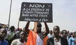 Un homme tient une pancarte sur laquelle est écrit « Non à la présence de l’armée française dans notre pays – Nigérien et fier » lors d’une manifestation à l’extérieur d’un aérodrome militaire français dans la capitale du Niger, Niamey, le 2 septembre dernier.
